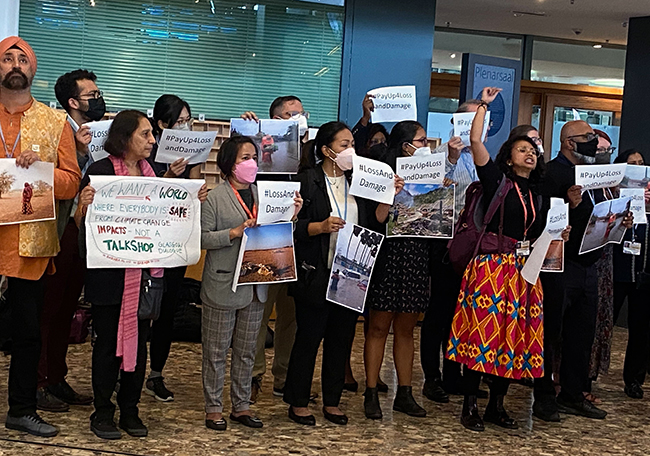Members of the WGC holding an action to call for funding for loss and damage at the Bonn Climate Conference.